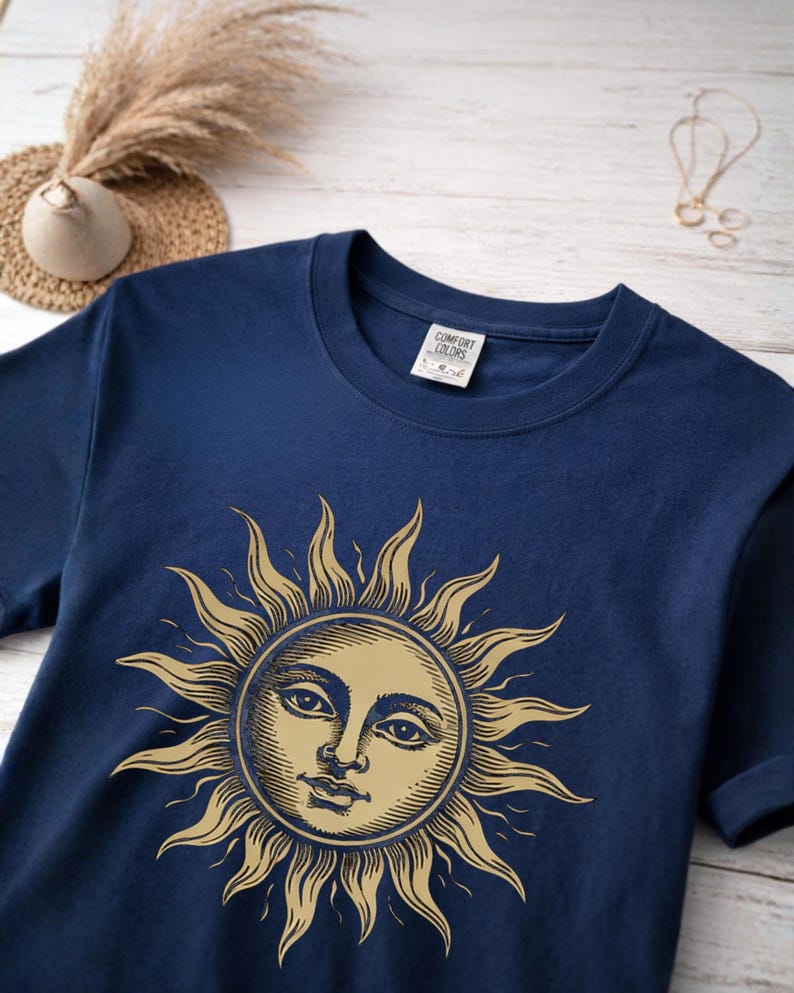 Navy unisex graphic t-shirt with vintage sun face design laid flat, a celestial boho shirt for astrology lovers and spiritual gift ideas, material close-up