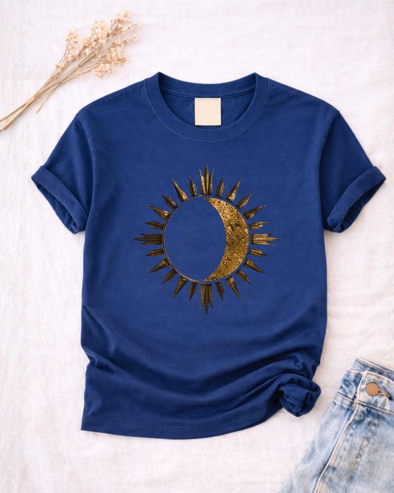 Flatlay of a blue navy tee with Sun and Moon minimalist celestial print. Detailed view of the front astrology graphic.