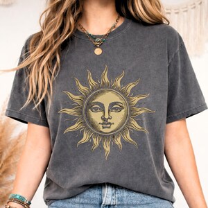 Close-up of a charcoal gray celestial sun face t-shirt featuring a vintage mystical graphic, perfect for boho fashion and astrology lovers