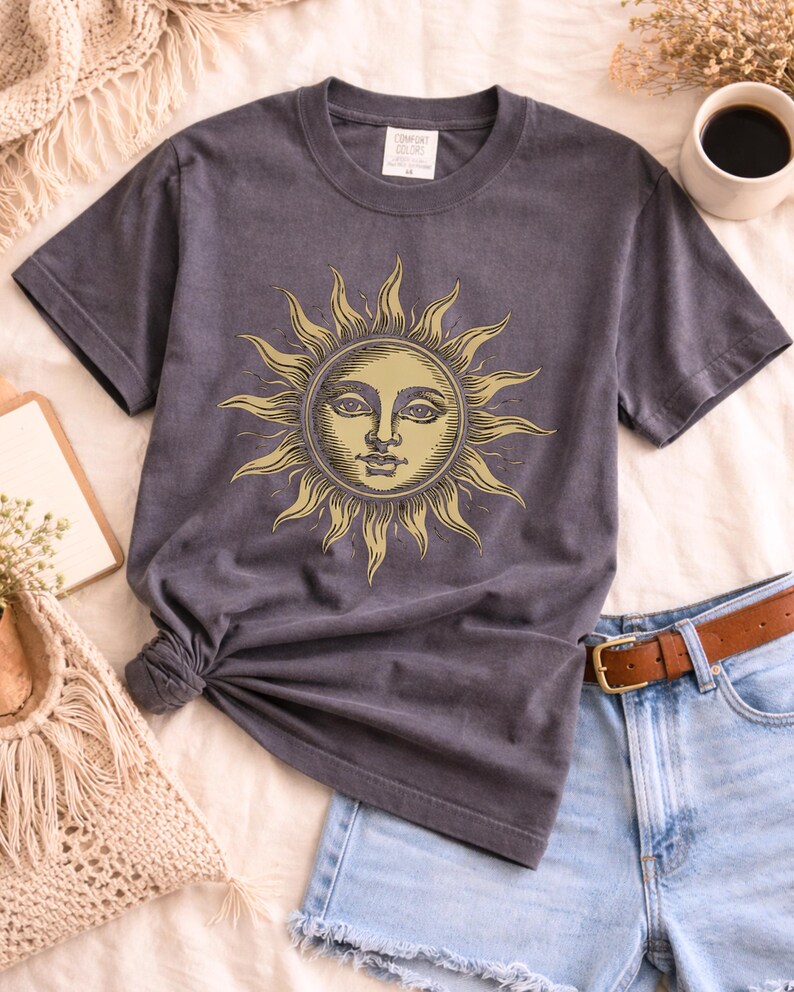 Grey comfort colors unisex t-shirt with vintage sun face design laid flat, a celestial boho shirt for astrology lovers and spiritual gift ideas