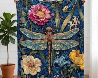 Op de afbeelding: Een blauwe deken met een gedetailleerd libellenontwerp, met turquoise en gouden vleugels, omringd door kleurrijke bloemen. Het bloemmotief omvat roze, gele en witte bloesems en groen gebladerte.
