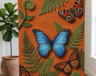 Op de afbeelding: Oranje plaid met gedetailleerde illustraties van vlinders en varens. De vlinders zijn in tinten blauw, oranje en bruin. De deken heeft een gebreide textuur, wat diepte aan het ontwerp toevoegt.
