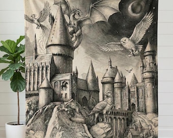 Op de afbeelding: Een zwart-wit deken met een gedetailleerde illustratie van kasteel Hogwarts, draken, uilen en andere magische wezens. De deken heeft het woord "HOGWARTS" in grote gotische letters, met de tekst "THE VALIANT PROTECTORS / A LEGACY OF MAGIC AND MIGHT" eronder.
