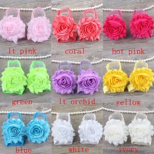 K&ouml;nnte beinhalten: Set mit 10 Paaren Baby-Sch&uuml;hchen mit Blumenverzierungen in verschiedenen Farben, darunter hellrosa, Koralle, pink, gr&uuml;n, helllila, gelb, blau, wei&szlig; und elfenbein.