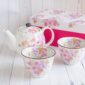 Pu&ograve; includere: Servizio da t&egrave; in ceramica bianca con teiera, due tazze e una confezione regalo. Il set &egrave; decorato con motivi floreali rosa, viola e gialli. La teiera ha un pomello viola scuro. La confezione regalo &egrave; bianca con interno rosa.