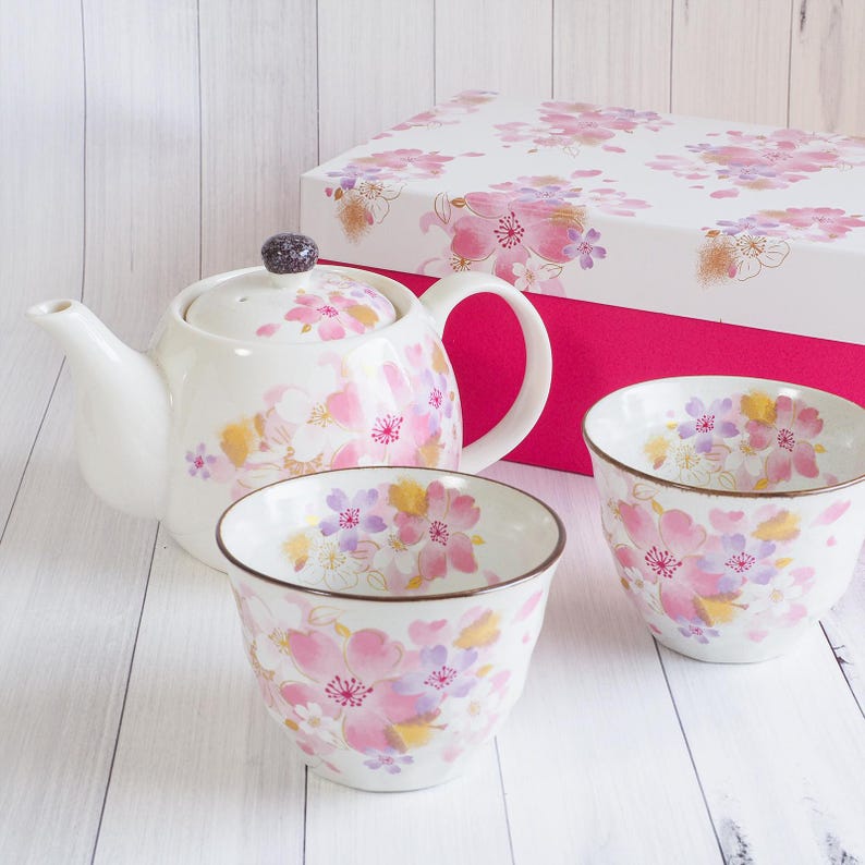 Pu&ograve; includere: Servizio da t&egrave; in ceramica bianca con teiera, due tazze e una confezione regalo. Il set &egrave; decorato con motivi floreali rosa, viola e gialli. La teiera ha un pomello viola scuro. La confezione regalo &egrave; bianca con interno rosa.