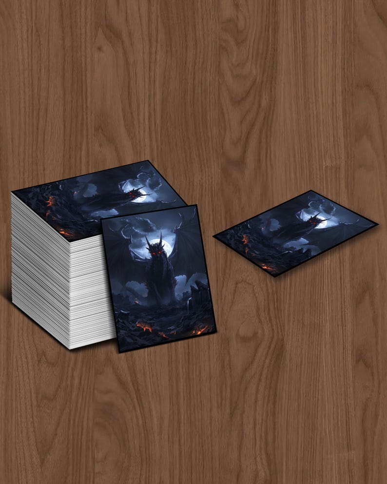 May include: A stack of rectangular cards featuring a dark fantasy illustration of a dragon with a full moon in the background. The dragon is black with red eyes and is surrounded by a dark, fiery landscape. Two cards are displayed separately.