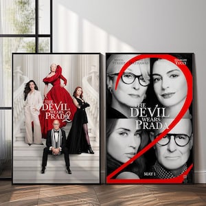 May include: Two framed movie posters. The left poster features the cast of "The Devil Wears Prada 2" with the movie title. The right poster has the movie title and the faces of Meryl Streep, Anne Hathaway, and Stanley Tucci.