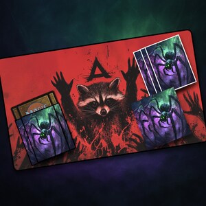 May include: A red playmat featuring a raccoon with raised hands and a black spider graphic. The playmat includes card sleeves with the same spider design and the word "MAGIC".