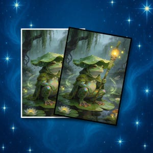 Op de afbeelding: Twee ingelijste prints met een grillig kikkerpersonage. De kikker draagt een groene capuchon en een bladhoed, en houdt een gloeiende staf vast. De achtergrond toont een moeras met waterlelies en een mystieke sfeer.