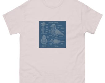 May include: A pale pink t-shirt with a blue diagram of a pigeon-drone. The diagram shows labeled parts and views of the bird, with the text "PIGEON-DRONE" at the top. The shirt is made of a soft, comfortable material.
