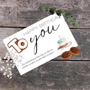 Peut inclure: Une carte de vœux d'anniversaire avec les mots "Happy Birthday To You" en écriture noire. La carte présente une illustration à l'aquarelle d'un gâteau et de deux bonbons. Le chiffre "10" est également sur la carte.