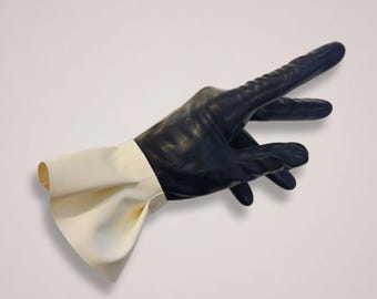 May include: A dark navy blue glove shaped like a hand with an extended index finger, featuring a wide, flared, off-white cuff at the wrist. The glove has a smooth, matte texture and is positioned in a pointing gesture against a plain background.