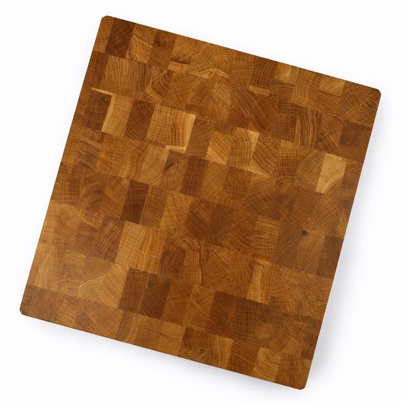 May include: A rectangular end-grain butcher block cutting board. The board is constructed from small, square pieces of light and dark brown wood, creating a mosaic-like pattern. The wood grain is visible throughout the surface.