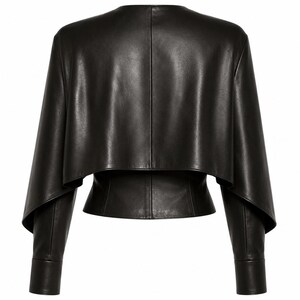 Rear view of a black genuine leather cape-style jacket with a cropped layered overlay and fitted long sleeves.
