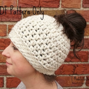 Op de afbeelding: Een witte gehaakte muts met een gat bovenop voor een paardenstaart. De muts heeft een dikke, omgeslagen rand. De tekst "PDF Pattern Only" staat bovenaan de afbeelding. De tekst "Made by the Best" staat onderaan de afbeelding.