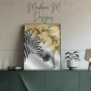 Peut inclure: Impression d'art encadrée représentant un zèbre et le visage d'une femme fusionnés. L'œuvre d'art présente une palette de couleurs neutres avec le texte "Madame M Designs". L'impression est exposée sur un meuble vert foncé.