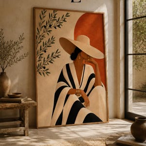Peut inclure: Une impression d'art mural rectangulaire représentant une personne portant un chapeau de paille à larges bords et un vêtement rayé noir et blanc. L'œuvre inclut une branche d'olivier stylisée à gauche et un grand cercle couleur terre cuite.