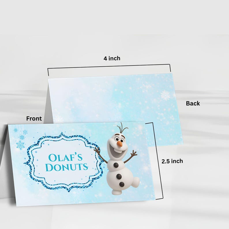 Puede incluir: Dos tarjetas de 10 cm por 6,35 cm con el tema Olaf's Donuts. La tarjeta frontal muestra un mu&ntilde;eco de nieve de dibujos animados y el texto "Olaf's Donuts" dentro de un marco de purpurina azul. El fondo es azul claro con copos de nieve.