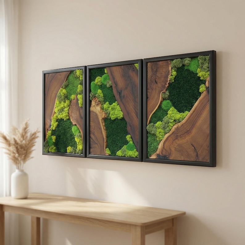 May include: Three framed wall art pieces. Each features a natural wood grain design with a black frame. The center of each frame is filled with green moss and plants, creating a natural, earthy aesthetic.