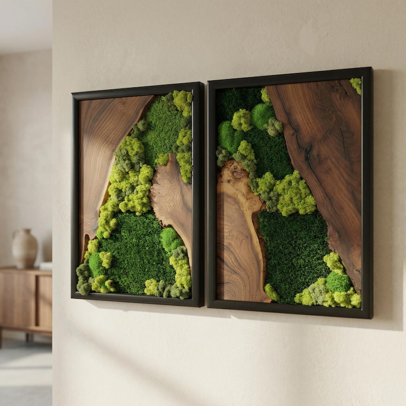 May include: Two framed wall art pieces. Each features a dark wood frame, a section of natural wood, and a vibrant display of green moss. The moss varies in shades, creating a textured, natural aesthetic. The artwork is mounted on a neutral-colored wall.