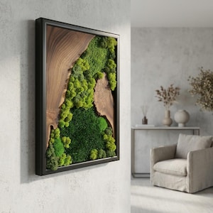 May include: A rectangular wall art piece featuring a natural wood and moss design. The artwork is framed in a black border, with a section of natural wood grain on the left and vibrant green moss filling the right side. The moss varies in shades of green.