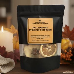 May include: A black pouch with a clear window displaying dried orange slices, star anise, and apple slices. The label reads "Fall Harvest Stovetop Potpourri" with a list of ingredients. The package is from Brandywine Simmer Pot Company.