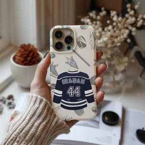 Off Campus phone case cream iPhone Pro gold trim Graham 44 navy jersey pattern, one hand knit sleeve autumn styling