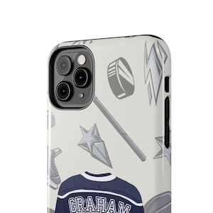 Cream iPhone 11 Pro Graham 44 hockey jersey case angled close-up showing puck stick lightning bolt pattern detail