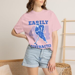 Pink tee blue Easily Distracted Garrett Graham 44 hockey player print, brunette model denim shorts boho setting
