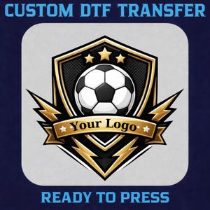May include: A custom DTF transfer design featuring a soccer ball within a shield, with the text "Your Logo" on a banner. The design includes gold accents and lightning bolt shapes, with the text "READY TO PRESS" at the bottom.