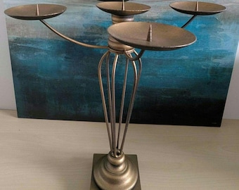 Chandelier en métal à cinq branches avec finition bronze patiné. Un mélange de styles classique et moderne, idéal pour décorer une table ou un buffet