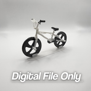 Könnte beinhalten: Ein Miniatur-BMX-Fahrradmodell mit weißem Rahmen und schwarzen Rädern und Sitz. Das Bild enthält den Text "Digital File Only" in weißen Buchstaben.