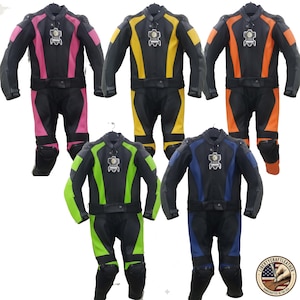 May include: Five black leather motorcycle suits with colored accents in pink, yellow, orange, green, and blue. Each suit has a matching jacket and pants, with protective padding on the knees and elbows. The suits are displayed on hangers.