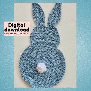 May include: A crochet pattern for a blue bunny with a white pom-pom tail. The pattern is a digital download and includes instructions for crocheting the bunny.
