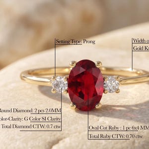 Puede incluir: Un anillo de oro con un rubí ovalado y dos diamantes redondos. El anillo tiene una banda de 1,3 mm y es de oro macizo de 14K. El rubí mide 6x4 mm y el peso total del rubí es de 0,70 ct. Los diamantes redondos son de 2,0 mm y el peso total de los diamantes es de 0,7 ct.