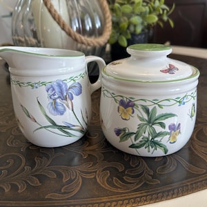 Peut inclure: Ensemble de trois mugs en céramique avec une finition mate et mouchetée. Les tasses sont de couleur crème, marron clair et marron foncé. Chaque mug a un design minimaliste et une anse arrondie.