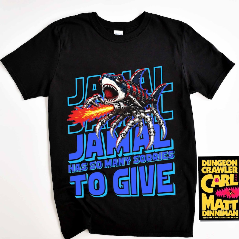 Może przedstawiać: Czarny t-shirt z grafiką hybrydy rekina-pająka ziejącej ogniem, napisem "JAMAL" w kolorze niebieskim i frazą "HAS SO MANY SORRIES TO GIVE". Widoczna okładka książki "Dungeon Crawler".