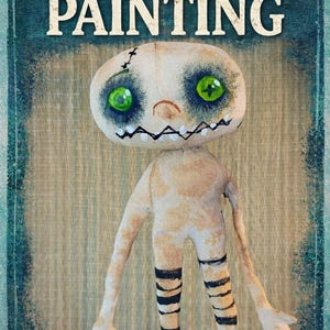 May include: A textile doll with a painted face and stitched details. The doll has large green eyes, a stitched mouth, and black and white striped legs. The image includes the text "TEXTILE DOLL PAINTING" and "PAINTING A TEXTILE DOLL".