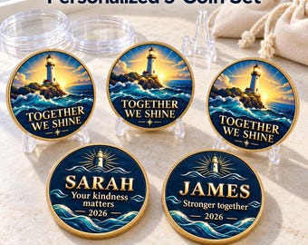May include: A set of five round gold-rimmed coins featuring a lighthouse, ocean waves, and the text "TOGETHER WE SHINE". Two coins are personalized with the names "SARAH" and "JAMES" alongside the year "2026" and custom phrases.