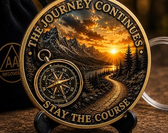 May include: A round gold-toned commemorative coin featuring a landscape with a sunset, mountains, a forest, and a winding path. A gold compass is embossed on the left. The text reads THE JOURNEY CONTINUES and STAY THE COURSE in gold lettering.