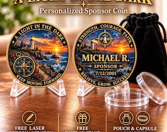 May include: Two round gold-toned coins featuring a lighthouse scene at sunset. One side displays a compass and the text A LIGHT IN THE DARK KEEP MOVING FORWARD. The other side shows MICHAEL R. SPONSOR 7/12/2001 with STRENGTH, COURAGE, FAITH, BELIEVE, GROW, SUCCEED.