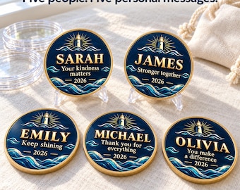 May include: Five circular gold-rimmed coins with a dark blue background featuring a lighthouse, ocean waves, and the text: Sarah Your kindness matters 2026, James Stronger together 2026, Emily Keep shining 2026, Michael Thank you for everything 2026, and Olivia You make a difference 2026.