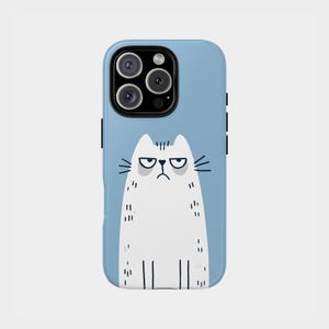 May include: A light blue phone case featuring a white cartoon cat with a grumpy expression. The cat has a black outline and whiskers. The case has black side buttons and a camera cutout.
