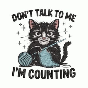 May include: Embroidered design featuring a black cat knitting with a blue yarn ball and needle. The text reads "DON'T TALK TO ME I'M COUNTING" in black. The cat has white markings and pink ears, with star accents.