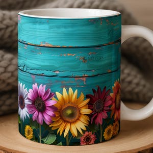May include: White ceramic mug featuring a vibrant floral design. The mug showcases a row of colorful sunflowers and other flowers against a teal, distressed wood background. The mug sits on a wooden coaster.