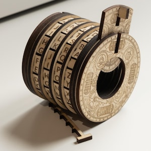 Può includere: Una ruota cifrata in legno con lettere incise e disegni intricati. La ruota ha più anelli rotanti, ognuno con un diverso set di lettere. Un piccolo pezzo di legno è staccato. Il design generale è di colore marrone chiaro.