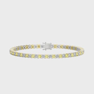 May include: Tennis bracelet with alternating yellow and clear gemstones set in a silver and gold band. The bracelet features a secure clasp and is displayed against a neutral background. A classic piece of jewelry.