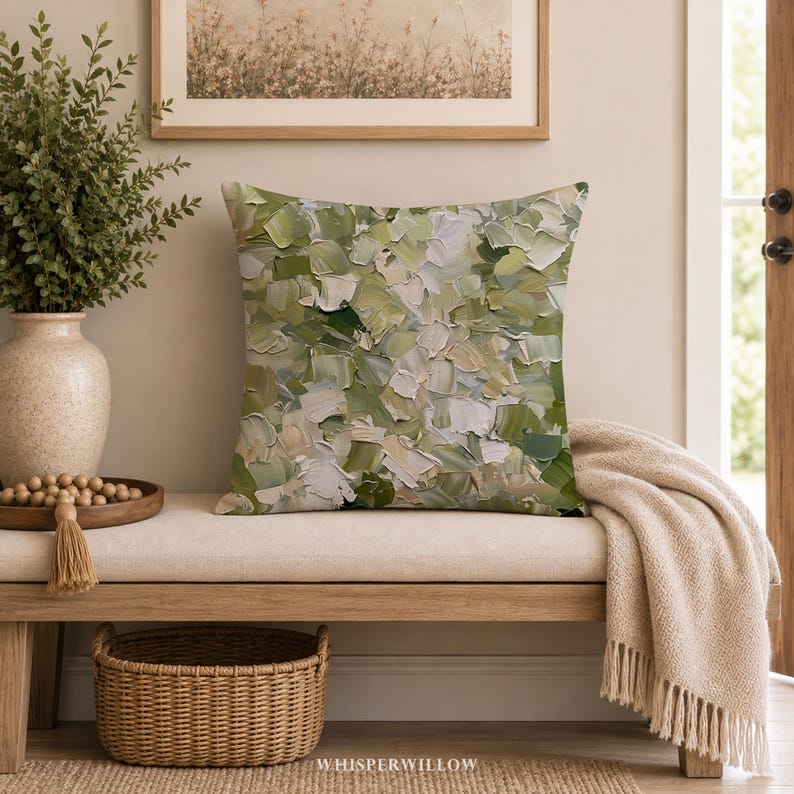 May include: A square throw pillow featuring an abstract oil painting design with thick, textured brushstrokes in various shades of sage green, olive, cream, and white. The pattern covers the entire front surface of the pillow in a dense, layered composition.