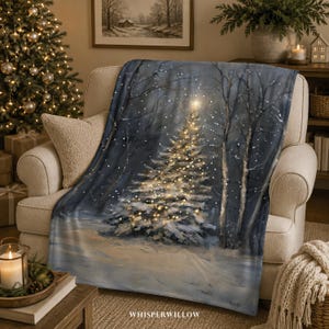 Könnte beinhalten: Eine weiche Wohndecke mit einem aufgedruckten Wintermotiv eines verschneiten Waldes bei Nacht. Das Design zeigt einen großen, beleuchteten Weihnachtsbaum, der in warmem gelbem Licht erstrahlt, umgeben von dunklen Bäumen und fallendem Schnee.